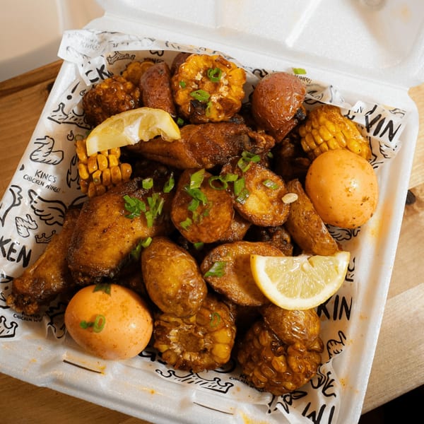 King's Chicken Wings meal with chicken, potatoes, corn, and eggs in a takeout container.